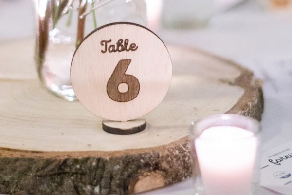 Close up view of a wooden laser etched table number.